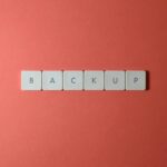 Simple-Backup-and-Recovery-Plans-Every-Small-Business-Needs-scaledjpg - IT Done Right LLC Free Close-up of keyboard keys spelling 'BACKUP' placed on a coral-colored surface. Stock Photo